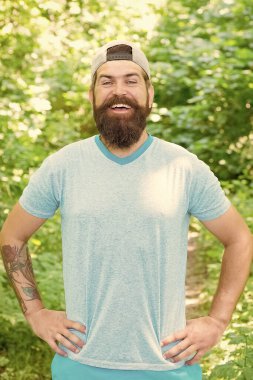 Doğaya giden yollar. Kamp yapmaya hazırım. Erkek sakallı turist şapkası takıyor. Spor ve spor kıyafetleri. Mutlu ve yakışıklı vahşi adam. Bıyıklı, vahşi, beyaz bir hippi. Gülümseyen sakallı adam