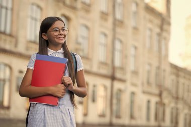 Acemi olmana izin ver. Gözlüklü mutlu çocuk kitapları tutuyor. Okulun gerekliliklerine dönelim. Okul kütüphanesi. Bilgi toplama günü. Resmi ya da gayri resmi eğitim. Harika olmaya başla, kopyalama alanı