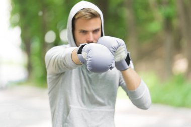 Sporcu konsantre boks eldivenleri. Sporcu odaklı yüz sporu eldivenleri dövüş becerileri doğa arka planı. Saldırı ya da savunma her zaman hazır olsun. Boksör boksa odaklandı