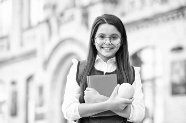 Diyet, doktorlardan daha çok iyileştirir. Elma ve kitap tutan mutlu liseli kız. Okul tatili. Meyve çerezi. Vejetaryen diyeti. Diyet ve diyet. Sağlıklı yiyecekler. Çocuk beslenmesi. Besleyici ve yüksek enerjili.