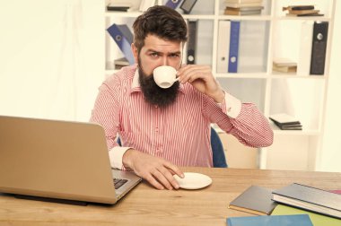 Görevde kalmak için kahve iç. İş adamı işyerinde kahve molasının tadını çıkarıyor. Sabahları sıcak kahve içmek. Ofis hayatı. Kafein onu daha üretken yapıyor.