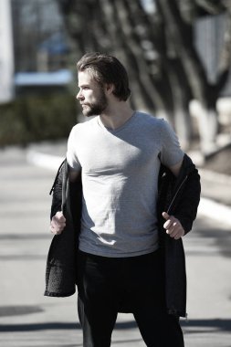 Gri tişörtlü adam güneşli bir günde terler.