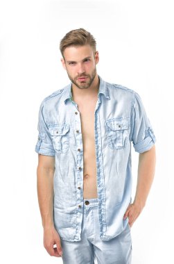 Adam düğmesiz keten mavi gömlekle çekici görünüyor. Sakince poz veren, el ele, beyaz arka planda bir adam. Tüylü adam rahat ya da resmi gömlek giyiyor. Moda konsepti