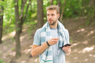 Fitness hedeflerinize teknolojiyle ulaşın. Formda adam akıllı telefonla antrenman yapıyor. Atletik adam forma girmek için teknolojiyi kullanıyor. Mobil teknoloji. Spor ve spor. Daha akıllı eğitim teknolojisi