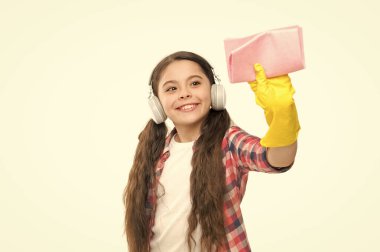 İşini çok seviyor. Küçük kız evi temizliyor. Oda servisi ve ev temizliği konsepti. Çocuk temizlik için toz bezi ve eldiven kullanıyor. Evde temizleyici var. Komik kız evi paspaslıyor ve müzik dinliyor.