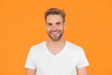 Yakışıklı, seksi adam. Karizma konsepti. Yüz bakımı. Güzel insanlar. Yakışıklı genç adam. Tıraşsız yakışıklı bir adam. Tüylü hippi beyaz tişört giyer. Yakışıklı adam poz veriyor. Karizmatik maço