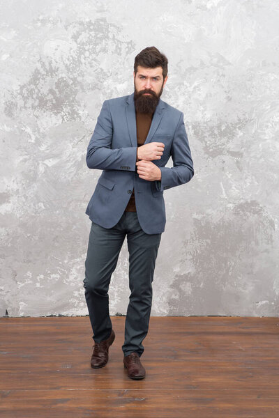 У него отличный стиль. Мужчина, красивый бородатый бизнесмен, носит роскошный официальный костюм. Мужская одежда и концепция моды. Жестокая модель. Стиль моды бизнесменов. Официальная одежда для офиса