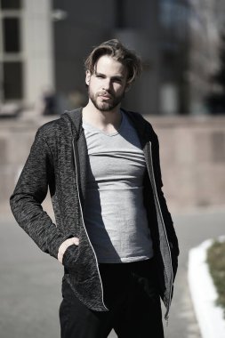 Elleri cepte olan adam sıradan kıyafetler giyer.