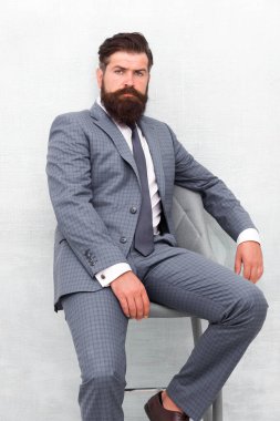 O kesinlikle etkileyecektir. Kendine güvenen bir iş adamı. İş adamı sandalyeye oturur. Resmi tarzda sakallı iş adamı. Sakallı ve bıyıklı bir iş adamı. Zeki ve profesyonel görünüm. İş elbisesi kuralı