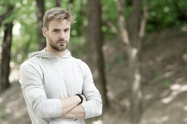 Kendinden emin ve fiziksel olarak fit. Kendine güvenen sporcu kollarını açık havada kavuşturur. Kaslı bir adamın kendine güveni. Atletik bir tip. Kendinden emin ve sağlıklı. Spor eğitimi ve antrenman. Gurur duy.