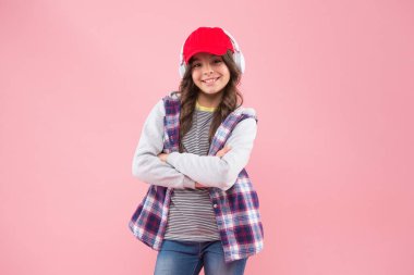 Modern yaşam teknolojisi. Okula dönüyorum. Sonbahar ya da bahar modası. Şapka takan ve kulaklık takan çocuk.