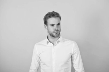 Beyaz gömlekli yakışıklı, kendine güvenen genç bir adam. İyi bakımlı bir iş adamı. Erkek berber ve kuaför. Güzellik ve moda. Yüzünde kıllı saçları olan şık, yakışıklı bir adam.