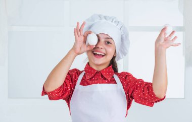 Neşeli kız evde pasta, yumurta pişiriyor.