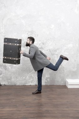 Hayallerinin peşinden git. Tatil için aksesuarlar. Erkekler için en iyi seyahat çantası. İyi giyimli, zarif sakallı bir adam ve klasik bir bavul. Zaman yolcusu konsepti. Eski moda çanta tasarımı. Eski ve eski