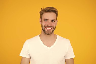 Yakışıklı, seksi adam. Karizma konsepti. Yüz bakımı. Güzel insanlar. Yakışıklı genç adam. Tıraşsız yakışıklı bir adam. Tüylü hippi beyaz tişört giyer. Yakışıklı adam poz veriyor. Karizmatik maço