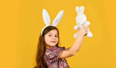 Mutlu Paskalyalar. Bahar tatili hazırlığı. Şefkatli aşk. İlkbahar konsepti. Küçük kız tavşan oyuncağı tutuyor. Mutlu bir çocukluk. Sevimli çocuk oyuncağıyla oynuyor. Oyuncakçı. Sevimli tavşan kulaklı kız.