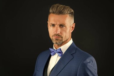 Yakışıklı manken. Yakışıklı etkinlik yöneticisi. Siyah arka planda smokin giyen adam. Mükemmel erkek. moda ve güzellik. Estetik gelişim konsepti. Özel bir randevu için hazırım. Resmi kıyafetli zarif bir adam.