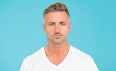 Saçları taranmış yakışıklı, olgun bir adam. Yüzünde kıllar, berber dükkanı.