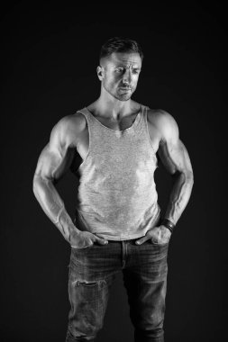 Güçlü ol. Sıradan tarzda siyah arka planda güçlü bir adam. Pazı ve kol kasları yapıyorlar. Kas egzersizi. Spor ve spor. Vücut bakımı ve sağlık. Sağlık ve diyet. Güçlü ol.