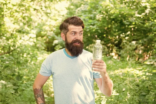 Hot Summer Heat. feel thirsty. bearded man look cheerful. brunette bearded man with water bottle in forest. brutal brunette bearded man drink water. mature guy with beard in wood. hot summer day