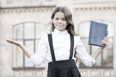 Yukarı. Eğitim zorunluluktur. Küçük çocuk dışarıda ellerle çaresiz bir jest yapıyor. Küçük kız ilkokul diploması almış. Eğitim konsepti. Eğitim için harika bir yer.
