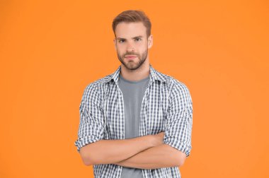 Erkekler için güven anlamına geliyor. Kollarını çapraz yapmış şık bir adam. Karizmatik manken. Yakışıklı, tıraşsız adam. Adam kareli gömlek giyiyor. Erkek güzelliği ve moda. Erkekler için moda.