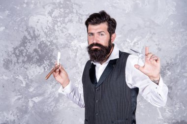 Tıraş bıçağı olan esmer bir hippi. Erkek güzellik ve moda. Kuaför makası.