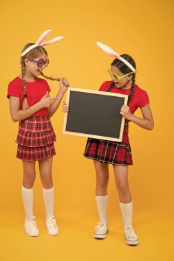 Mutlu Paskalyalar. Bahar geliyor. Paskalya tavşanı çocukları. Çocuklar tavşan kulaklarıyla oynar. Tavşan kulağı takan sevimli küçük kızlar. Paskalya kompozisyonu. Yumurta avı eğlencesi. Geleneksel bahar tatili. Boşluğu kopyala