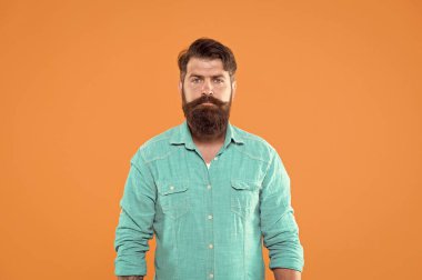 Kendi tarzında. Ciddi turuncu bir geçmişi var. Sıradan kot giyen sakallı adam. Erkek giyim mağazası. Beyaz adam bıyıklı ve sakallı. Vahşi bir adamın hippi görünüşü. Berber Dükkanı