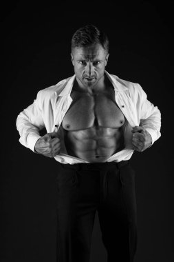 Güçlü bir adam açık tişörtlü, formda, karın kaslı, resmi siyah arka plan, karın kaslı.