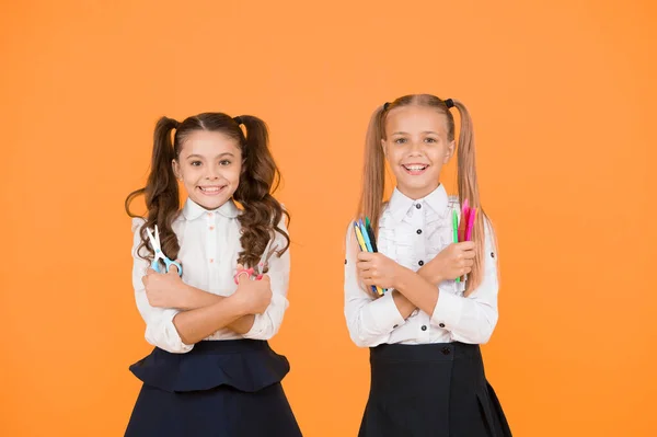 Inspira a tus hijos a ser creativos. Niños felices sosteniendo tijeras y marcadores. Niños pequeños sonriendo con útiles herramientas sobre fondo amarillo. Actividades artísticas y artesanales para niños pequeños —  Fotos de Stock