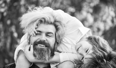 Sakallı zalim adam, iyi baba. Baba ve oğul. Küçük oğlum. Bahar yürüyüşü. Babalık. Mutlu bir aile. Babalar Günü. Doğada yaşayan küçük bir çocuk ve baba. Hipster ve küçük oğlu çiçek açan bahçede