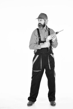 Güvenlik önlemleri. Beyaz arka planı delinmiş şapkalı bir adam. Profesyonel inşaatçı delik açıyor. Sondaj konsepti. Perforatör ve ısırık. Güçlü matkap. Matkap al. Araç kutusu ipuçları sondaj ve onarım