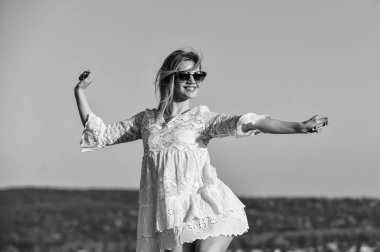 Bana bak. Gökyüzünde sarı saçlı seksi kız. Mükemmel gün batımı ya da gün doğumu. Güzel kadın güneş gözlüğü takıyor. Kadın yaz modası. Açık havada beyaz elbiseli şehvetli bir güzellik. bahar havası