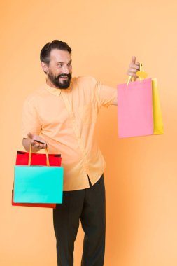 Alışveriş yap ve keyfine bak. Alışveriş bağımlısı sarı arka plan. Olgun adam alışveriş torbalarını tutar. Kağıt torbalı mutlu müşteri. Satış ve alışveriş. Alışverişte olması gerektiği gibi, kopyalama alanı