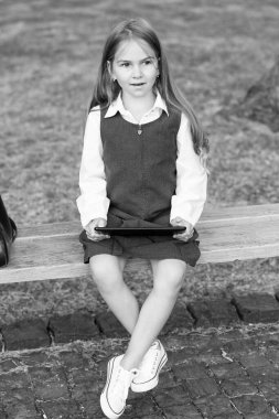 E-öğrenme atölyesi. Küçük çocuk dışarıda online çalışıyor. Küçük kız öğrenmek için tablet bilgisayar kullanır. E-öğrenme aracı. Dijital eğitim. E-okul. Sanal sınıf. Giyin. Çevrimiçi kurslar