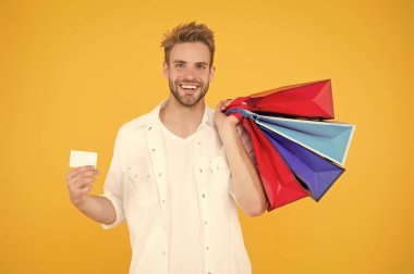 Mutlu adam alışverişi ödeme metodunu kullanır. Alışveriş koliği kredi kartını boşaltmış. İnternetten hediyeler ve hediyeler al. Paketleme çantası ve indirim kartı olan bir tezgahtar. satın alma teslimat servisi