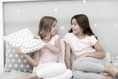 Eğlenmek için akşam vakti. Pijama partisi fikirleri. Kızlar mutlu en iyi arkadaşlar ya da güzel pijamalı kardeşler ve yastıklı pijama partisi. Kız kardeşler pijama partisinde eğleniyor. Yastık savaşı pijama partisi