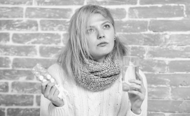 Rahatlama aranıyor. Hap ve su bardağı tutan sağlıksız bir kadın. İlaç ve artan sıvı alımı. Soğuk algınlığı ilacı alan tatlı hasta kız. Soğuk algınlığı veya grip belirtilerini tedavi eden hasta bir kadın.