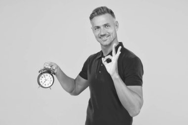 Peki, tamam. Mutlu adam çalar saati tutuyor, tamam işareti gösteriyor. Dakiklik ve doğru zaman tutma. Kronometri ve zaman tutma. Saat doğru zamanı verir.