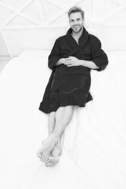 Bornozlu adam dinleniyor. Genel sağlık için gerekli dairesel ritmi sürdürmek. Yakışıklı bir adam yatakta dinleniyor. Uyumadan önce dinleniyorum. Her gece yeteri kadar uyuyorum.