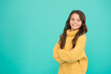 Duygusal bir bebek. Pozitif çocuk. Hayata olumlu yaklaşım. İlham. Pozitif ruh hali. Çocuk psikolojisi. Sevimli gülümseyen kız sarı süveter giyer turkuaz arka plan. Pozitif olma kavramı. İyi titreşimler.
