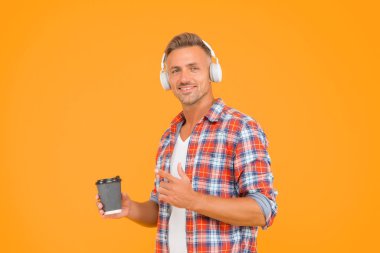 Güne başlamak için bundan bir fincan iç. Mutlu adam kahve bardağını işaret ediyor. Sabah alışkanlıkları. Müzik eğlenceli. Modern yaşam tarzı. Sıradan bir tarz. Tüm sabah boyunca enerjin açık olacak.