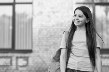 Mutlu gençler sırt çantası taşır. Okul bahçesinde gülümseyen bir çocuk. çocukluk mutluluğu. Kız derse hazır. En iyi eğitimi al. Bilgi Günü kavramı. Modern okul eğitimi. Okula dönüyorum. Boşluğu kopyala