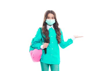 COVID-19 sırasında maskeli çocuk kopya alanı için elini açık tutuyor ve ürünü sunuyor.