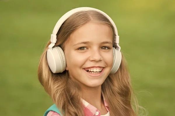 Music is life. Happy child listen to music outdoors. Little girl wear headphones playing music. Music lesson. New technology. Modern life. Listen and learn. Fun and entertainment