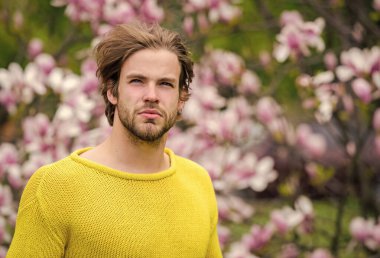 Tazelik ve uyanış. Adam çiçek parkında rahatlıyor. Botanik bahçesi. Botanik ve doğa. Yumuşak çiçekler. Hippi çiçeğin tadını çıkarır. İlkbahar konsepti. Erkek çiçekli arka plan çözüldü. Bahar güzeli