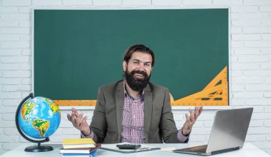 Güzel gülümseme. gayri resmi eğitim. Erkek öğrenci ders sırasında sınıfta oturur. Sınavı geç. Konuyu öğrenmek. Okula dönüyorum. Öğretmenler günün kutlu olsun. Sakallı vahşi adam kostüm giyiyor.