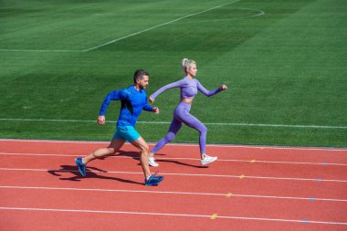 Enerji dayanıklılığı. Zıplayan sporcu tipler. Erkek ve kadın spor eğitmeni koşar. Fitness çifti eğitimi