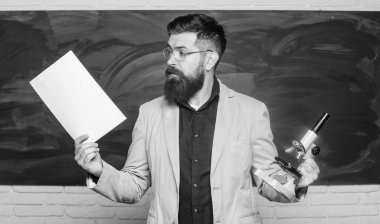 Öğretmen sakallı adamın elinde belgeler ve mikroskop geçmişi var. Biyoloji onun tutkusu. Talep eden öğretmen. Sınıfta ders veriyorum. Teoriyi açıklıyorum. Üniversite ve lise. Test için hazırlanın.